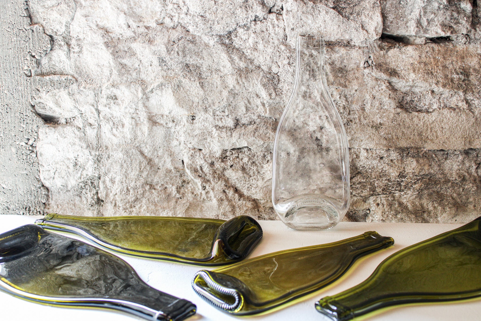 Une planche apéritive en demi bouteille de rosé de Bourgogne avec quatre autres bouteilles recyclées.