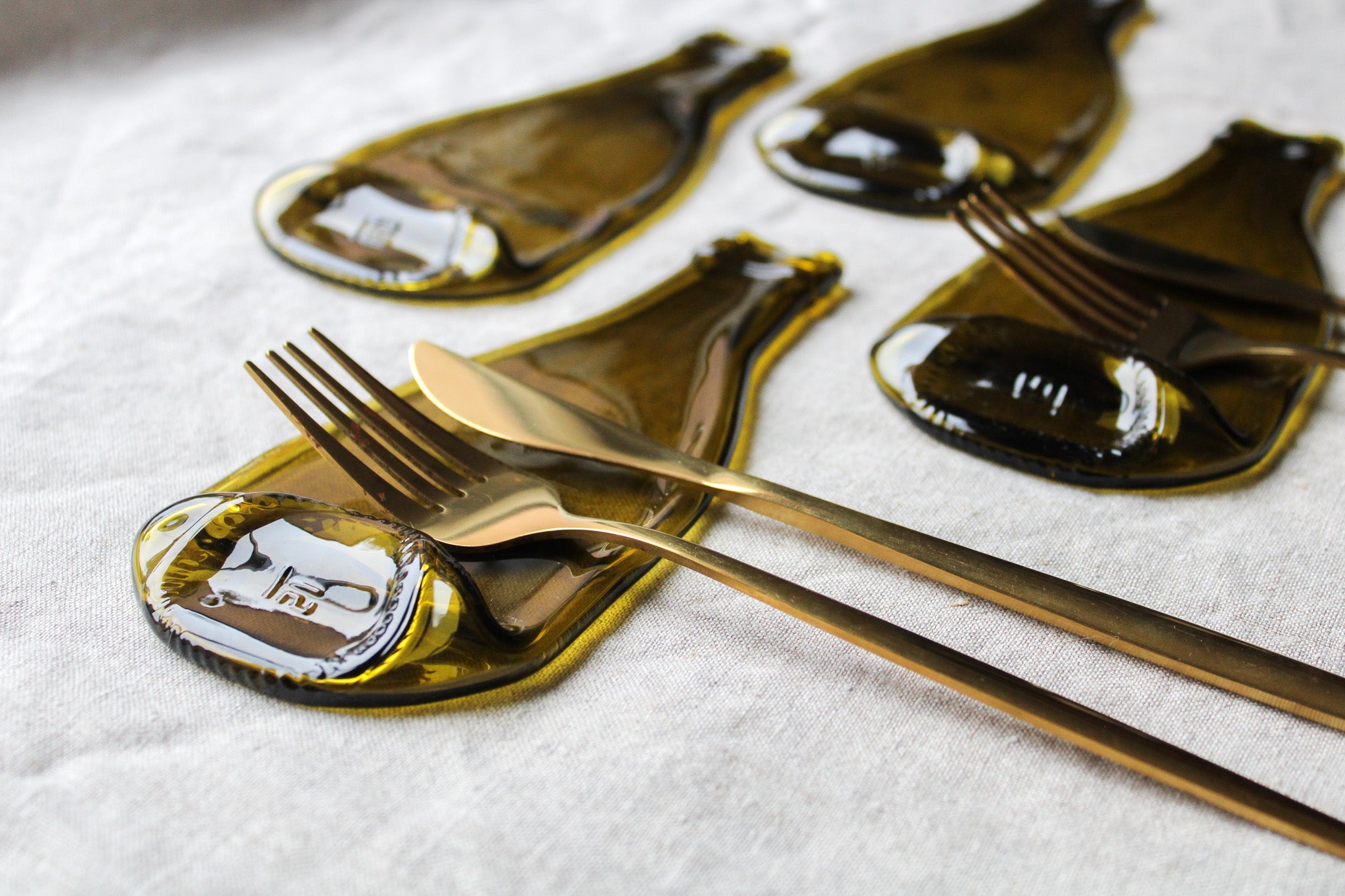 Quatre repose-couverts avec fourchette et couteau doré.